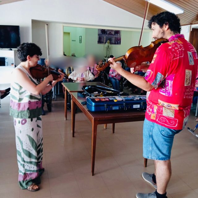 Sara Llano e Nuno Soares a tocarem música num lar para idosos.